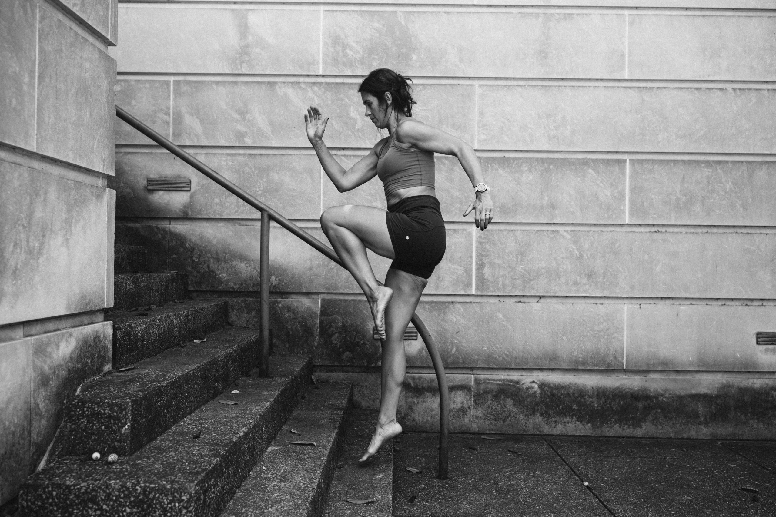 Black & White image of Sue Roeske doing exercise in stairs